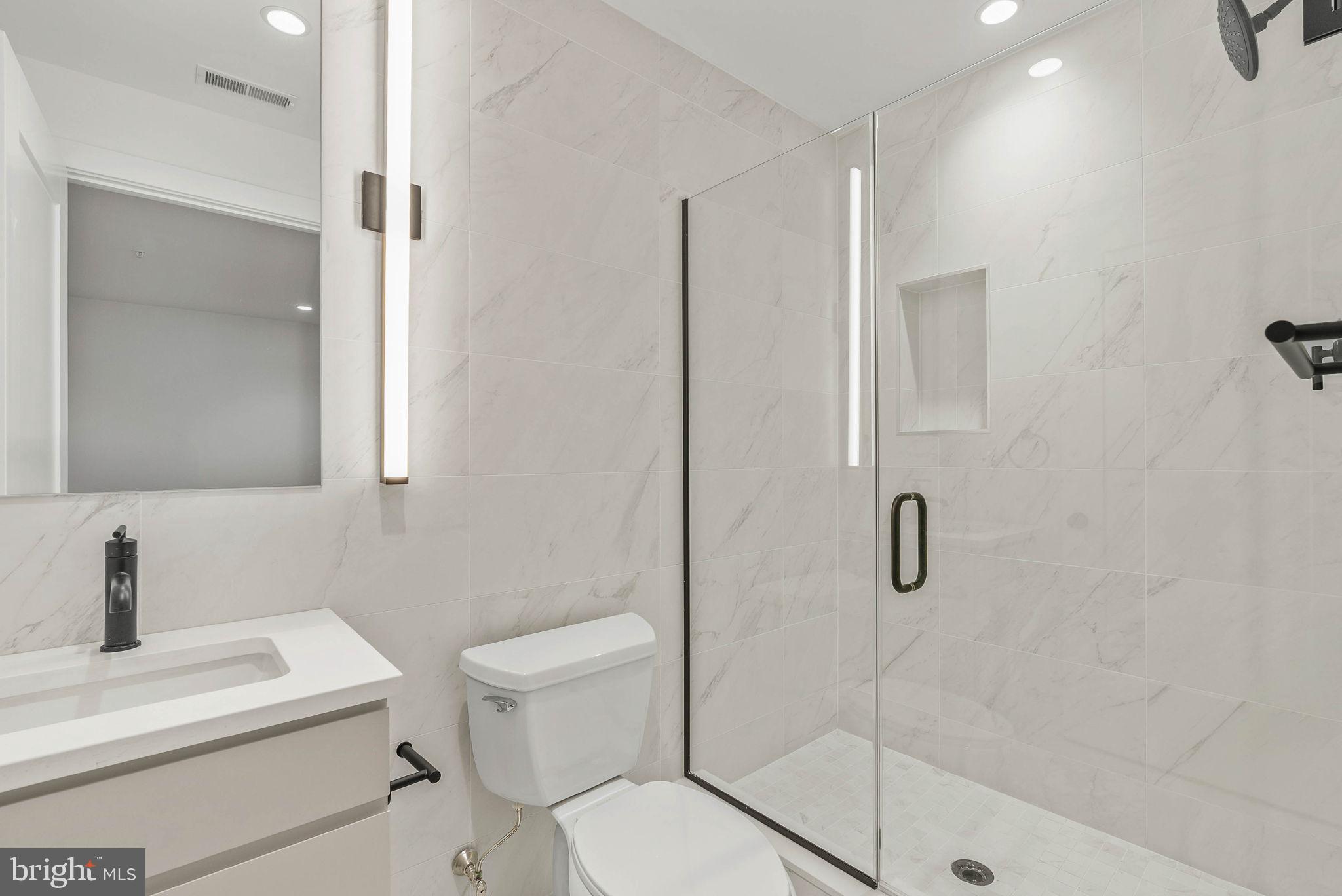 650 Fairmount Avenue, Unit A2 Philadelphia, PA 19123 - Photo 34 of 40 a bathroom with a toilet sink vanity and shower