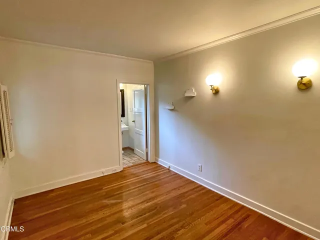 a view of empty room with wooden floor and cabinet