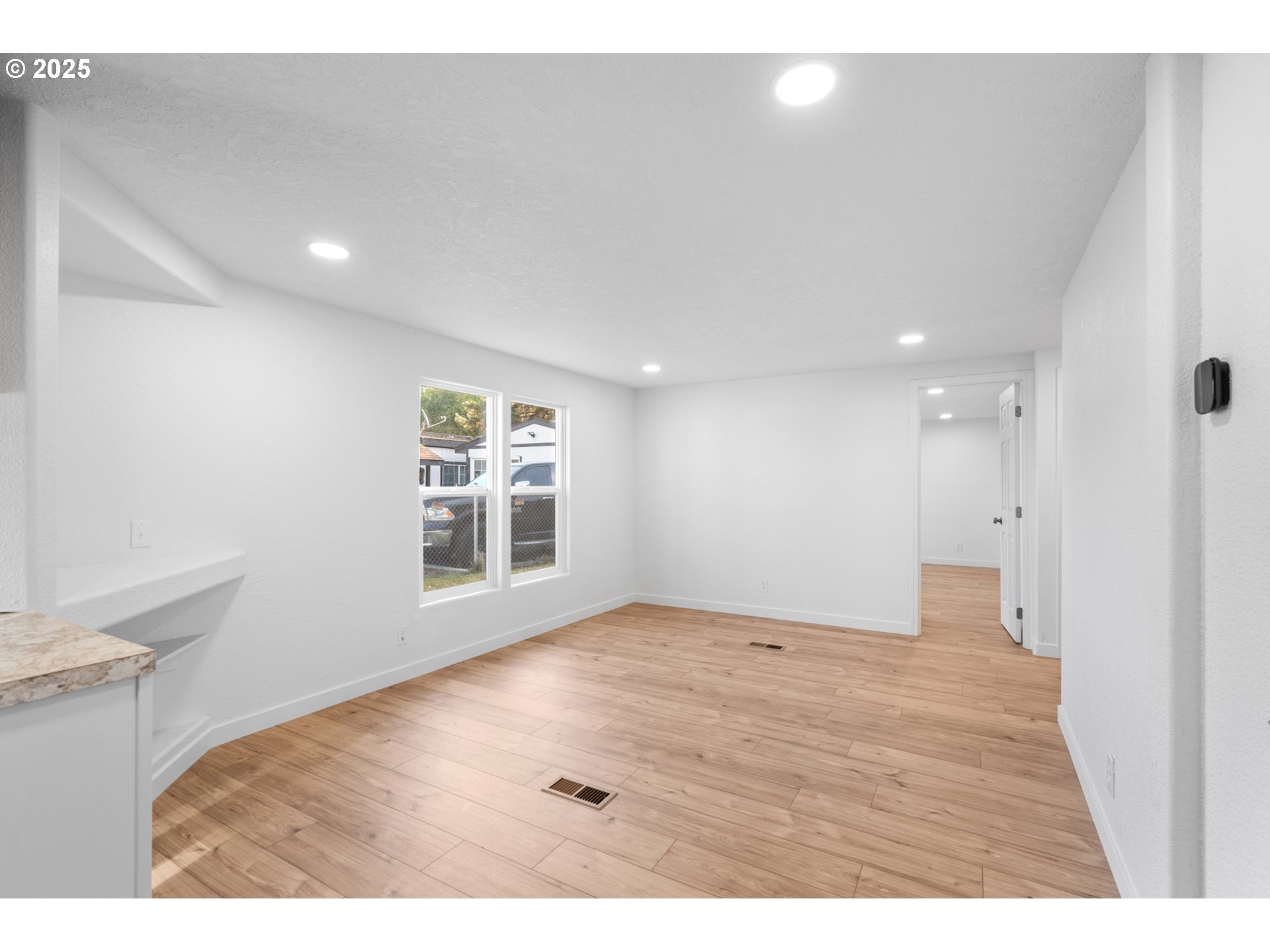 1175 Southwest Sandy Drive Hermiston, OR 97838 - Photo 8 of 30 a view of an empty room with wooden floor and a window