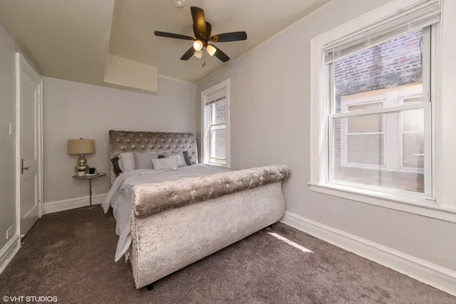 an empty room with a window and a fan