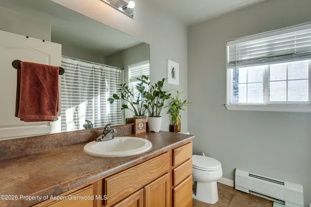 a bathroom with a granite countertop sink and a mirror with toilet