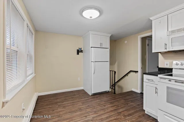 a kitchen with granite countertop a refrigerator and a stove top oven