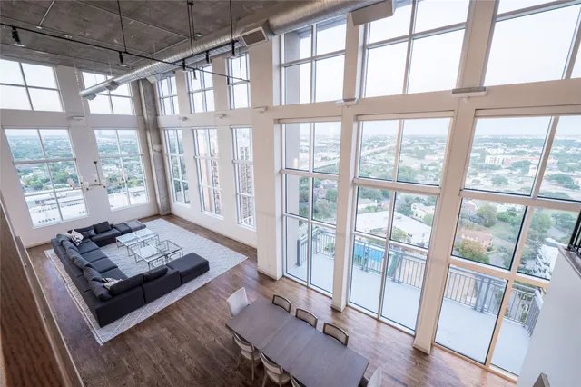 a living room with furniture and floor to ceiling windows