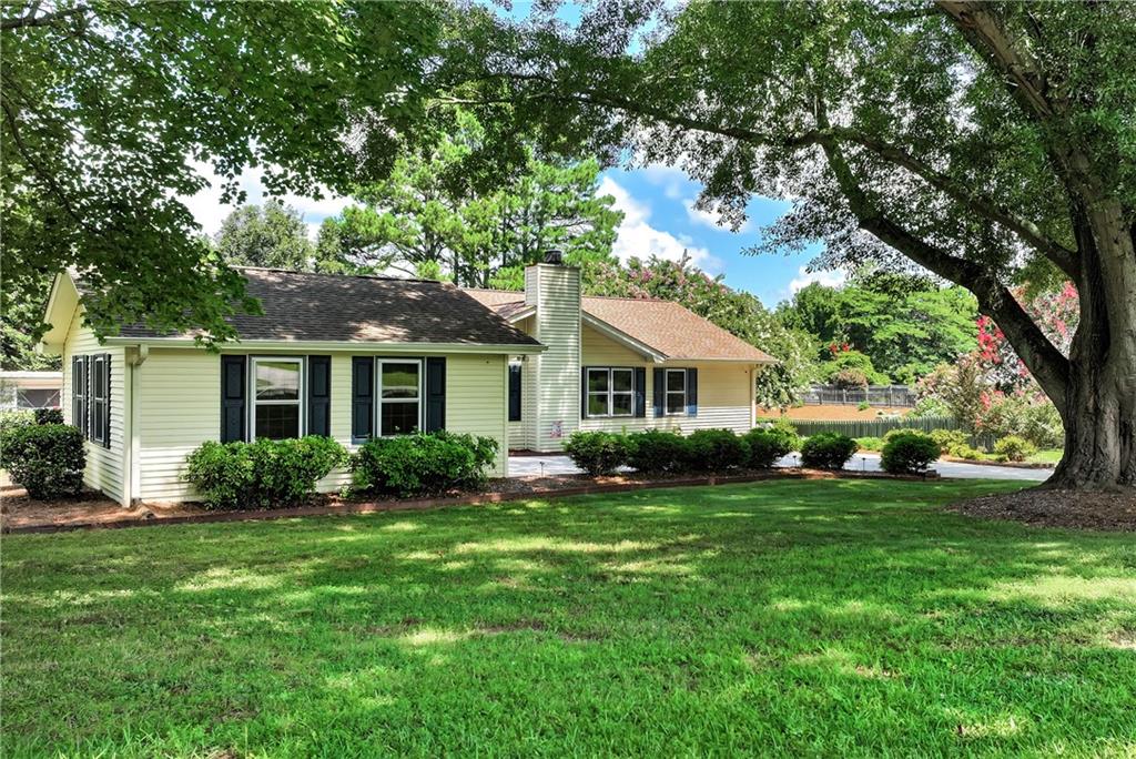 5658 Raintree Trace Oakwood, GA 30566 - Photo 51 of 55 a front view of a house with a garden and trees