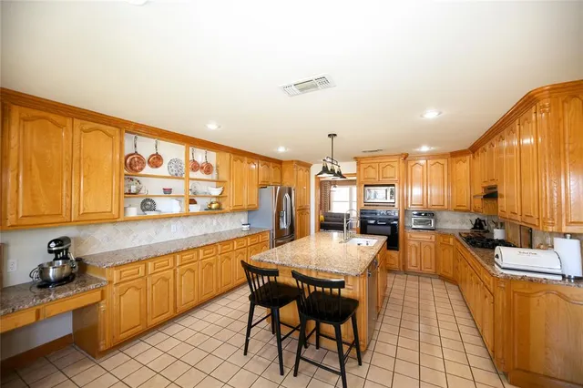 a large kitchen with lots of counter and chairs