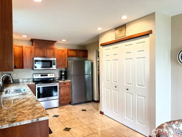 a kitchen with granite countertop a sink stainless steel appliances and cabinets