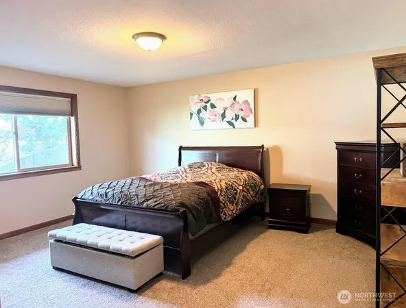 a bedroom with a bed and dresser with rug