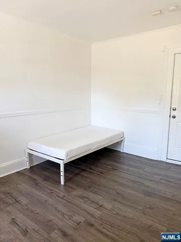 a view of a room with wooden floor and white walls
