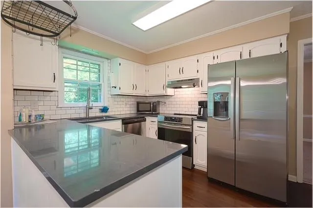 a kitchen with a refrigerator a sink a stove a microwave and cabinets