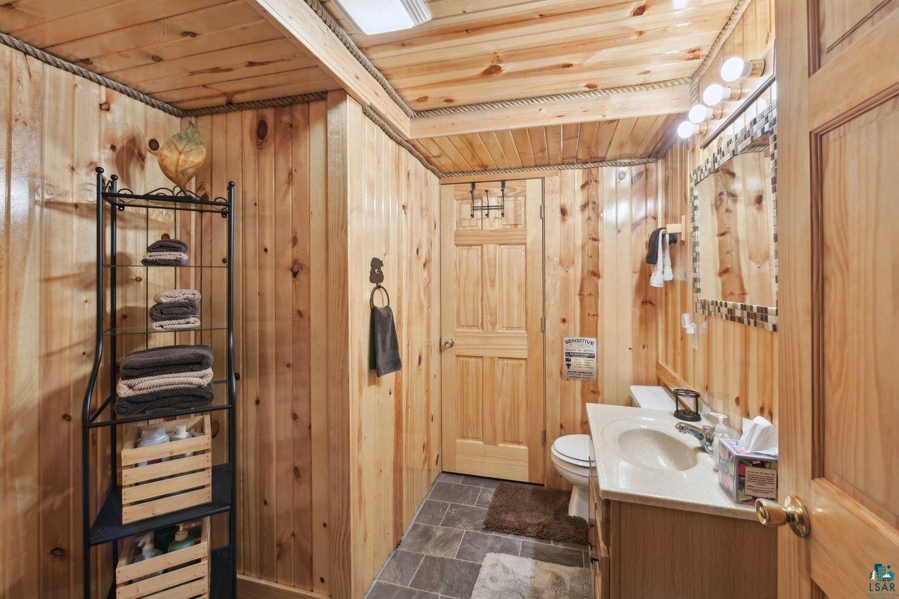 28255 Friendly Valley Road Washburn, WI 54891 - Photo 21 of 34 Bathroom with vanity, toilet, wooden ceiling, and wooden walls
