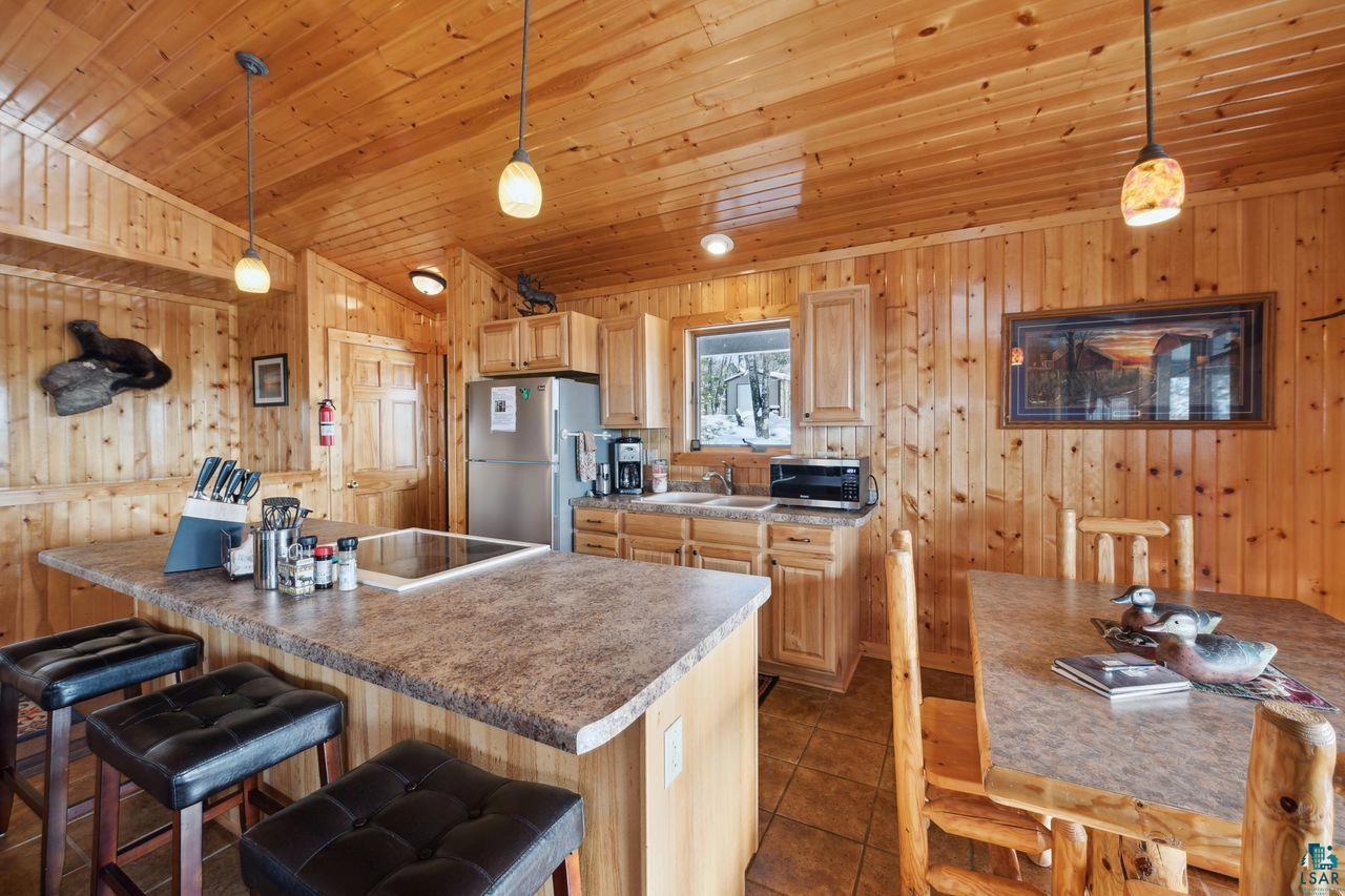 28255 Friendly Valley Road Washburn, WI 54891 - Photo 7 of 34 Kitchen featuring light brown cabinetry, hanging light fixtures, dark tile patterned flooring, and appliances with stainless steel finishes