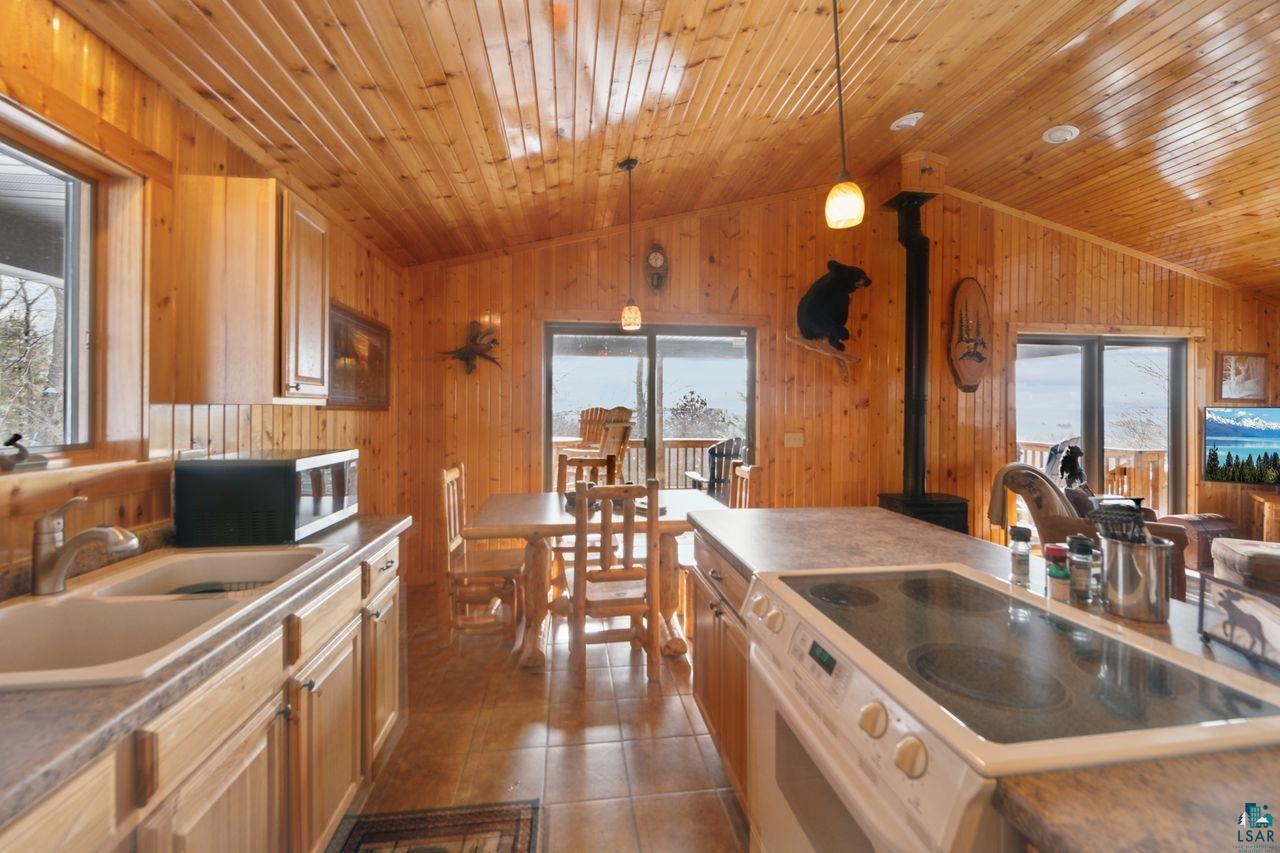 28255 Friendly Valley Road Washburn, WI 54891 - Photo 8 of 34 Kitchen with decorative light fixtures, white range oven, sink, and vaulted ceiling