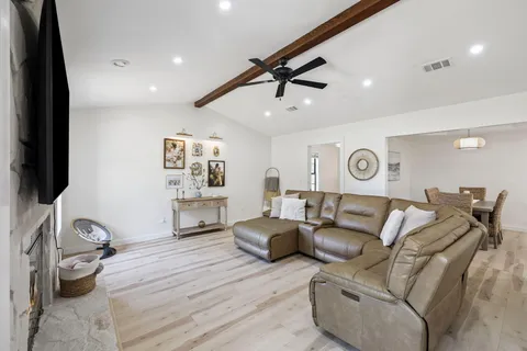 a kitchen with stainless steel appliances kitchen island granite countertop a sink dishwasher stove refrigerator and cabinets with wooden floor