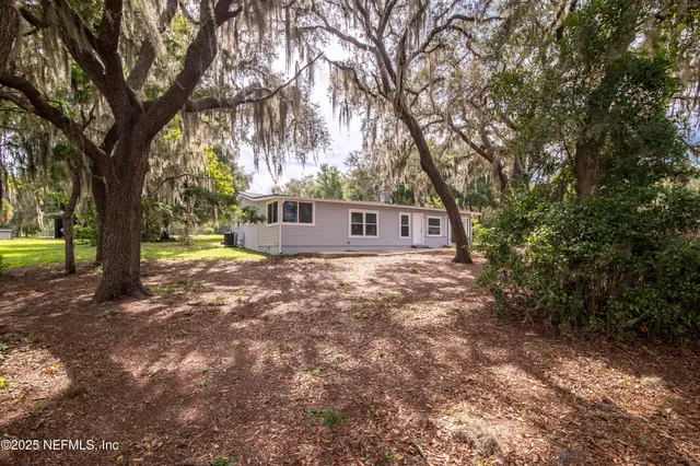 a front view of a house with a yard and tree