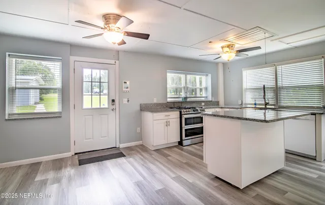 a kitchen with stainless steel appliances granite countertop a sink cabinets and wooden floor