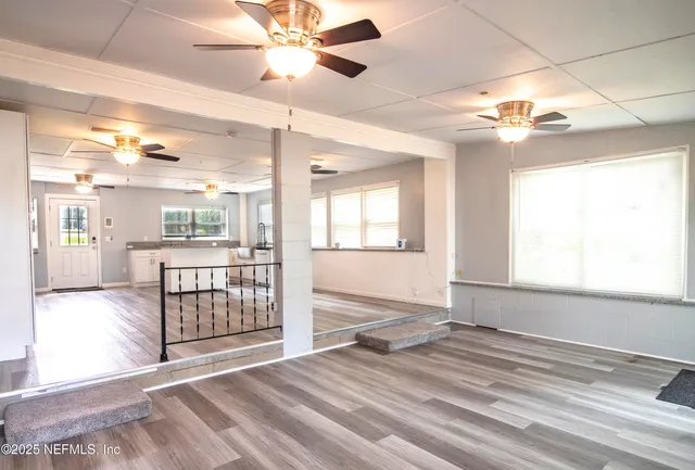 en empty room with windows and ceiling fan