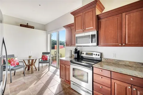 a kitchen with stainless steel appliances granite countertop a stove top oven a sink dishwasher and cabinets with wooden floor