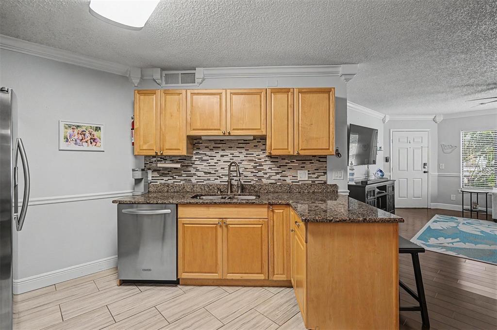 1550 South Belcher Road, Unit 525 Clearwater, FL 33764 - Photo 12 of 28 a kitchen with stainless steel appliances granite countertop a refrigerator sink and cabinets