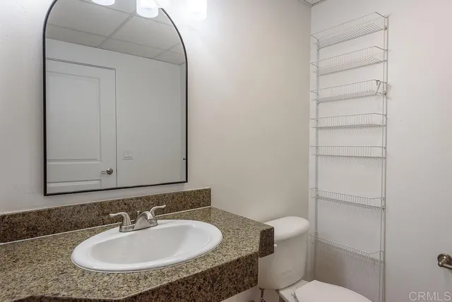 a bathroom with a sink a toilet and a mirror