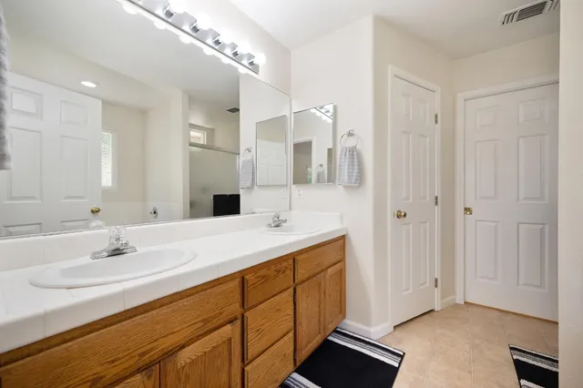 a bathroom with a double vanity sink mirror and