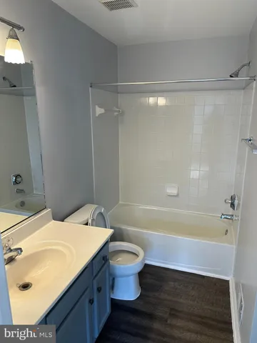 a bathroom with a sink and mirror with bathtub