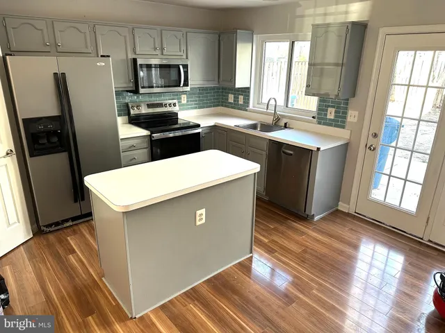 a kitchen with stainless steel appliances a refrigerator sink and microwave