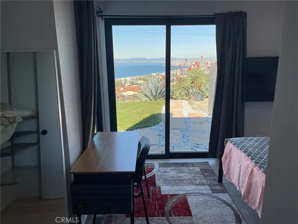 a view of a room with a large window and wooden floor