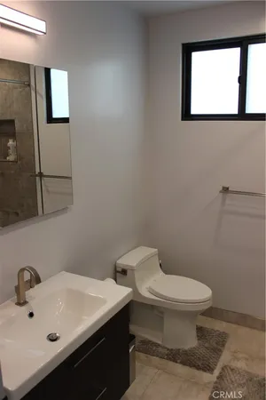 a bathroom with a sink a toilet and mirror
