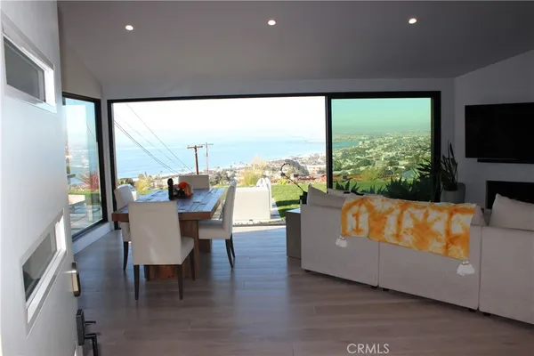 a living room with furniture a large window with kitchen view