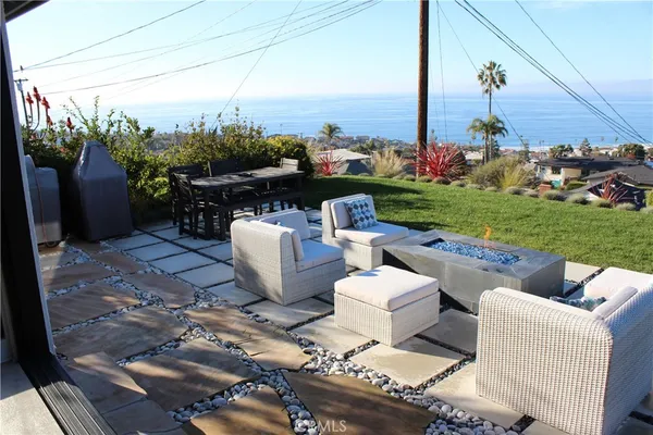 a view of a patio with furniture and a garden