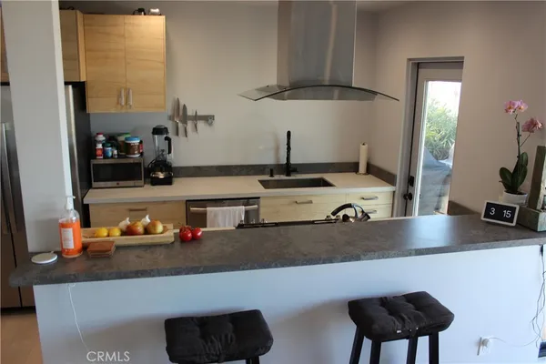 a kitchen with a sink a stove and a wooden floor