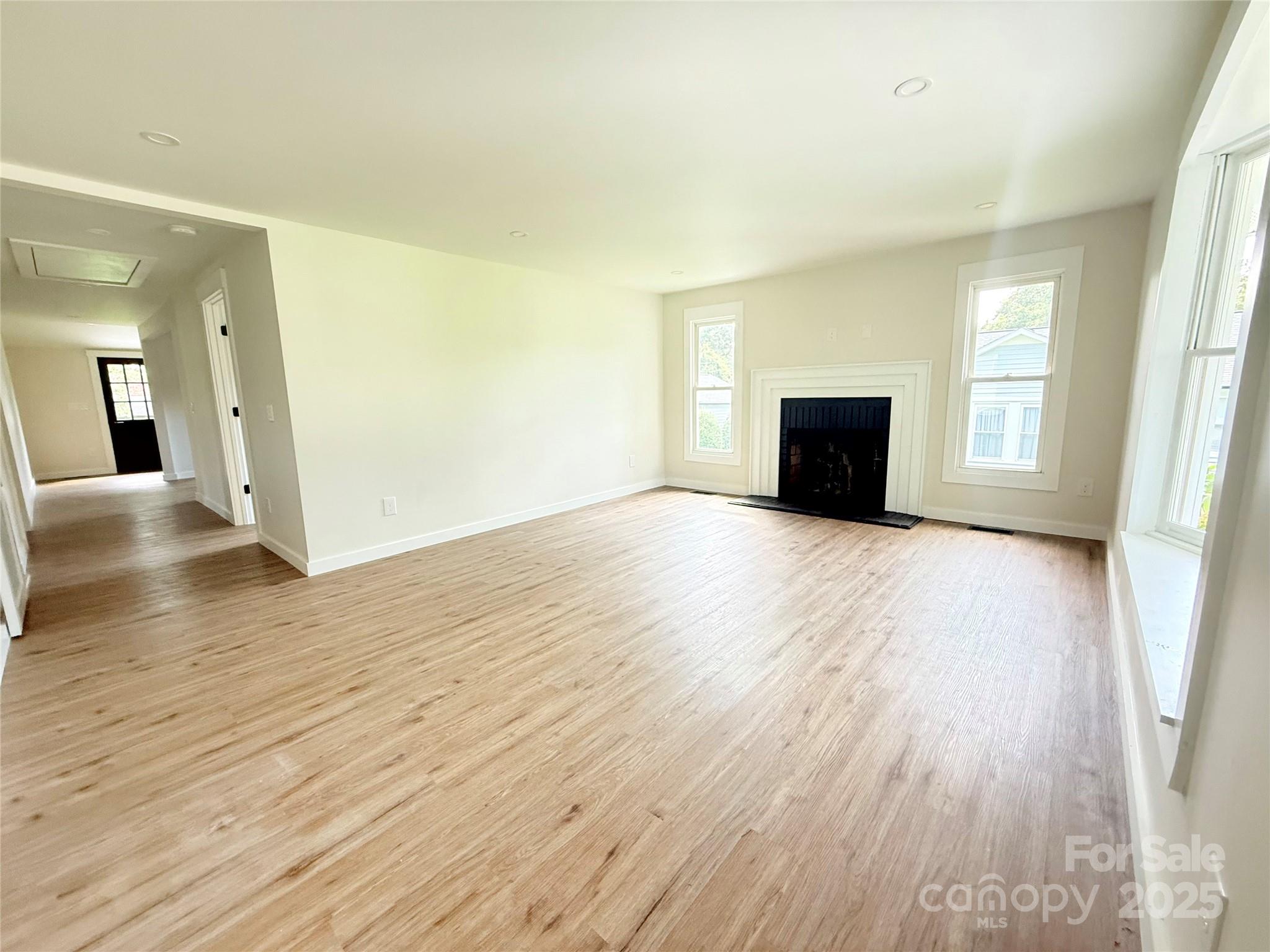 668 Union Cemetery Road Southwest Concord, NC 28027 - Photo 3 of 24 an empty room with wooden floor and windows