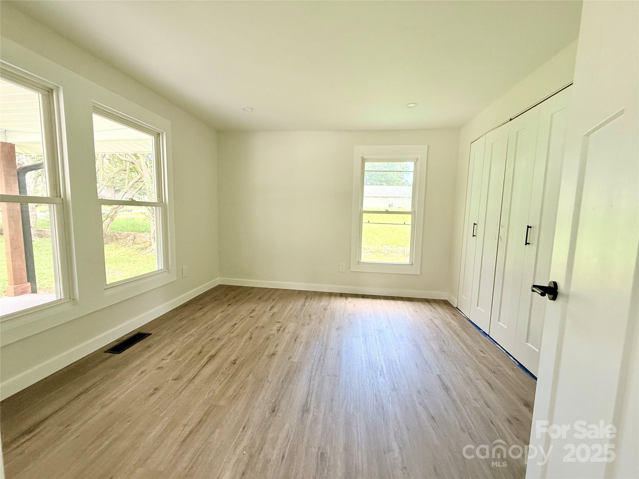 668 Union Cemetery Road Southwest Concord, NC 28027 - Photo 7 of 24 an empty room with wooden floor and windows