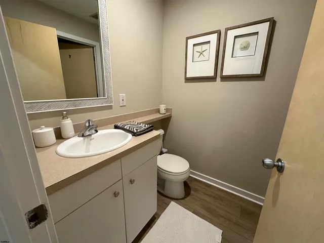 a bathroom with a granite countertop sink mirror vanity and toilet