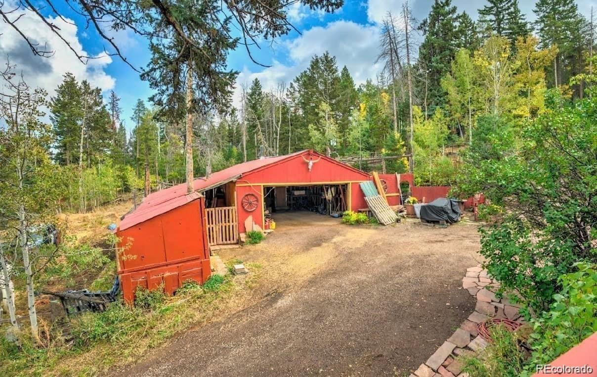 19424 Silver Ranch Road Conifer, CO 80433 - Photo 17 of 17 a backyard of a house with large trees and furniture