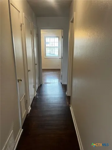 a view of a hallway with wooden floor and staircase