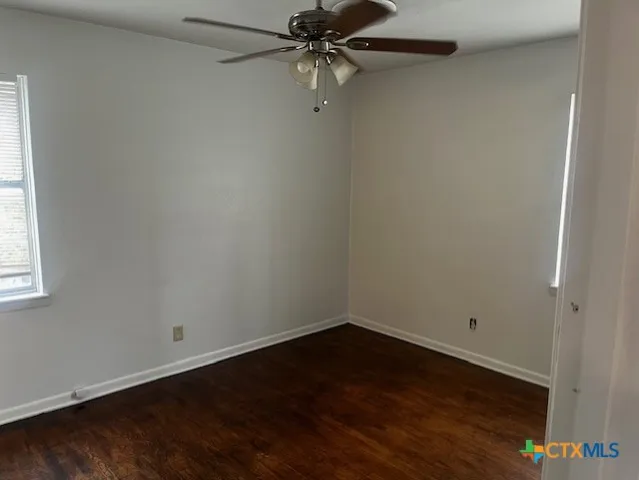 an empty room with a window and a ceiling fan