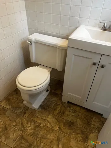 a white toilet sitting next to a white sink