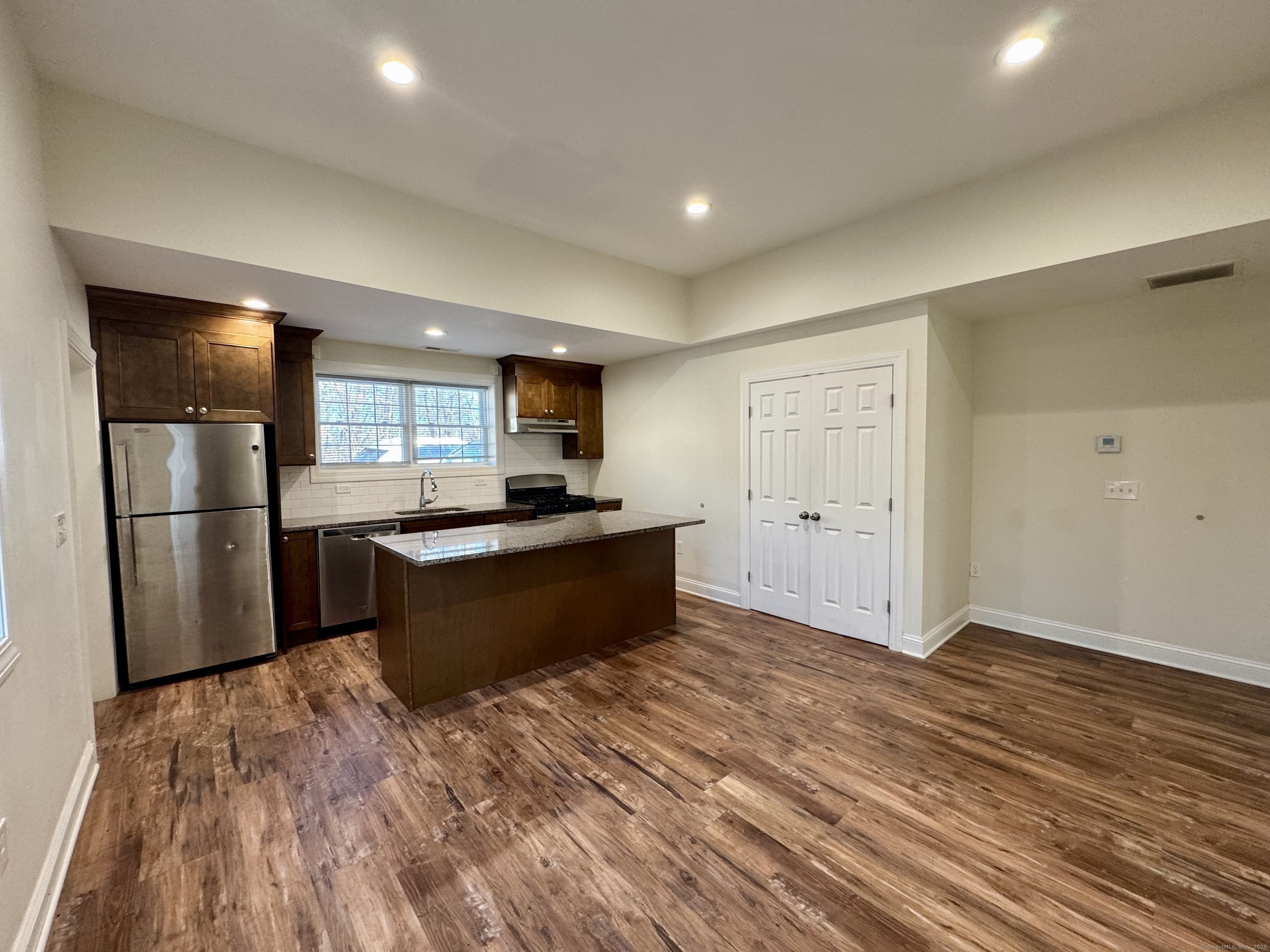 950 Lindley Street Bridgeport, CT 06606 - Photo 8 of 14 a large kitchen with a refrigerator and wooden floor