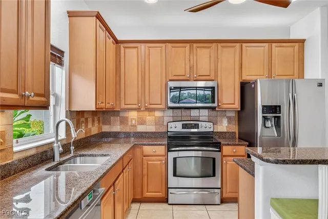 a kitchen with granite countertop a stove a sink and a microwave