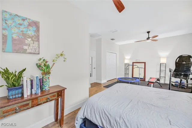 a bedroom with a bed a potted plant on dresser and a window