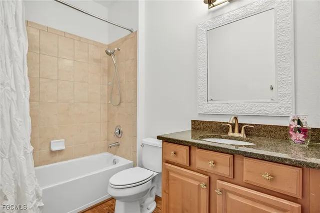 a bathroom with a granite countertop sink a toilet and shower