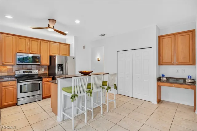 a kitchen with stainless steel appliances granite countertop a stove top oven a sink dishwasher and a refrigerator