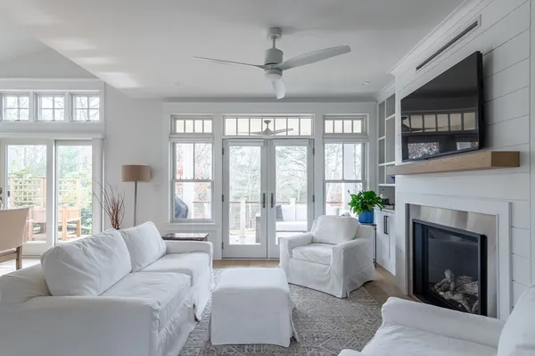 a living room with furniture a large window and a fireplace