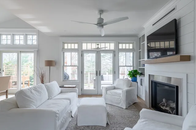 a living room with furniture a large window and a fireplace