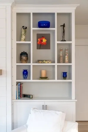 a living room with lots of books and a painting on the wall