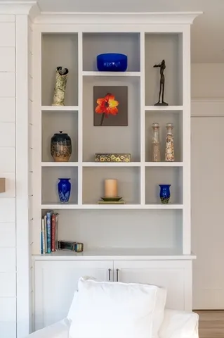 a living room with lots of books and a painting on the wall