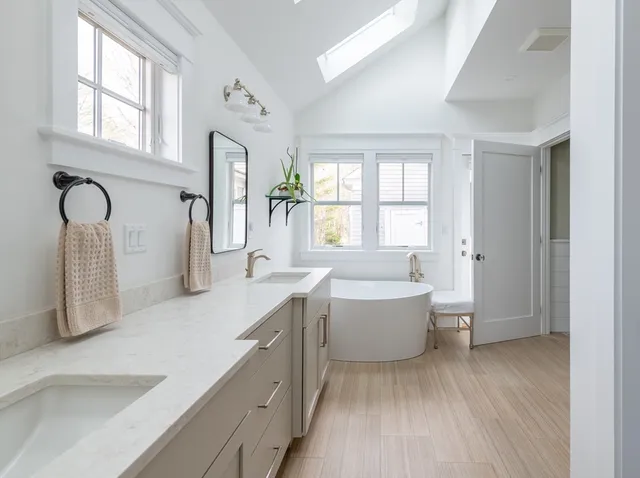 a spacious bathroom with a bathtub sink and mirror
