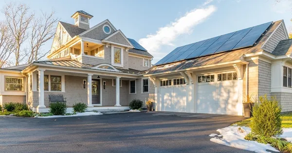 a view of a white house with large windows and a table and chairs