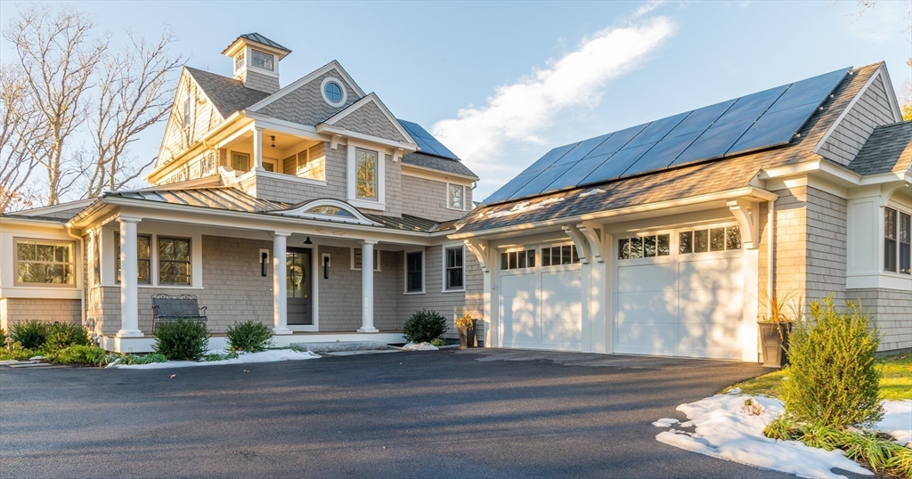 75 Streeter Hill Road Falmouth, MA 02556 - Photo 2 of 32 a view of a white house with large windows and a table and chairs
